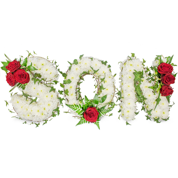 A striking memorial display spells the single word SON in three carefully modelled capital letters, each letter formed from a thick, uniform layer of small white spray chrysanthemums that create a serene, cloud-like surface. The white chrysanthemums convey purity and peaceful remembrance; their tightly clustered petals produce a full, almost tactile field that reads from the front pew to the back of a chapel. Woven through these white forms, lively green ivy snakes along the letter profiles, its trailing stems and glossy leaves adding organic contrast, depth, and the symbolism of enduring memory. Deep, velvety red roses serve as poignant focal accents: three full blooms are nestled into the upper left curve of the S, a single prominent red rose is placed at the bottom centre of the O and surrounded by soft, fern-like greenery, and another vertical grouping of three red roses adorns the right side of the N. The careful placement of these red roses balances the composition visually and offers an emotional counterpoint-love and grief enclosed within purity. Set against a clean white background and lit with gentle, natural illumination, the arrangement reads as an expertly crafted sympathy piece suitable for funeral services, wakes, or a graveside tribute. The combination of white chrysanthemums, vivid ivy, and passionate red roses communicates a message of deep affection, sorrow, and lasting remembrance for a beloved son.