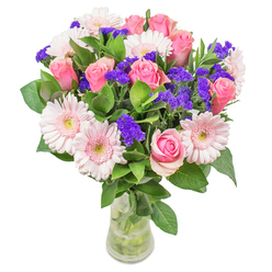 As your local florist near Nine Elms, I take delight in orchestrating this luminous bouquet-a dance of blush-toned gerberas and time-honoured pink roses inspired by the gentle ambience of nearby Battersea and the changing hues found in morning markets. Soft pinks meld seamlessly, reminiscent of watercolour washes across the springtime sky, while vivid violet statice punctuates the arrangement with spirited contrast. The greenery is cool and dewy, as if just gathered at dawn from a hidden Thames-side garden, anchoring the airy blooms above. Embraced in a minimalist glass vase, the pastel and purple hues glow softly in the light, inviting an appreciative gaze. This bouquet, ideal as a cheerful get-well message or as a refined accent for a contemporary flat overlooking the Nine Elms skyline, reflects careful craftsmanship and the joy of sharing floral beauty with our neighbourhood.